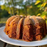 ['Close-up side view of a brown butter pumpkin bundt cake topped with a maple glaze.', 'Detailed view of a moist pumpkin bundt cake with a glossy maple glaze drizzling down the sides.', 'Side profile of a luscious brown butter pumpkin bundt cake, showcasing its texture and glaze.', 'Rich pumpkin bundt cake with a golden brown color and a smooth maple glaze, captured from the side.']