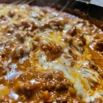 ['Close-up view of a creamy Chili Cheese Dip with melted cheese on top.', 'Side view of a delicious Chili Cheese Dip with visible chili and cheese layers.', 'Vivid image showcasing a bowl of Chili Cheese Dip with a smooth creamy texture.', 'Tasty Chili Cheese Dip with chunks of cheese and chili, presented in a close-up shot.']