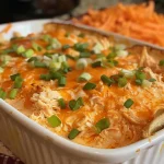 ['A close-up view of creamy Buffalo Chicken Dip in a crockpot, garnished with cheese.', 'Juicy Buffalo Chicken Dip showcased in a slow cooker, featuring a rich, creamy texture.', 'Side angle of a crockpot filled with Buffalo Chicken Dip, highlighting the melted cheese and ingredients.', 'Delicious, savory Crockpot Buffalo Chicken Dip in a slow cooker, ready to serve.']