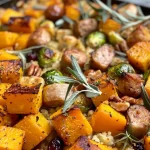 ['Close-up of a hearty Harvest Casserole filled with butternut squash, brussels sprouts, and chicken sausage.', 'Side view of a delicious Harvest Casserole featuring colorful vegetables, chicken sausage, and garnished with fresh herbs.', 'Juicy Harvest Casserole showcasing a mix of diced apple, pecans, and cranberries in a warm dish.', 'A vibrant bowl of Harvest Casserole with butternut squash and herbs, highlighting the texture and ingredients.']