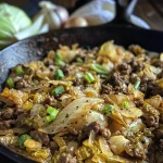 ['Juicy ground beef and bright green chopped cabbage in a skillet.', 'Close-up of a hearty skillet dish featuring ground beef and diced cabbage.', 'Sizzling ground beef mixed with vibrant chopped cabbage in a frying pan.', 'Cooked ground beef and chopped cabbage dish, garnished and ready to serve.']