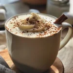 ['Close-up of a creamy Homemade Vanilla Steamer with whipped cream and marshmallows on top.', 'Side view of a frothy Homemade Vanilla Steamer, garnished with nutmeg and a stick of cinnamon.', 'Delicious homemade vanilla steamer in a clear glass, showing layers of creaminess and toppings.', 'Rich and inviting vanilla steamer drink with whipped cream and cinnamon, served in a cozy setting.']