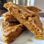 ['Close-up view of a golden maple pumpkin scone with a flaky texture.', 'Side angle of a moist maple pumpkin scone, showcasing its rich color and glaze.', 'Detailed shot of a pumpkin scone, highlighting the maple syrup drizzle on top.', 'Close-up of a freshly baked pumpkin scone, emphasizing its crumbly and inviting appearance.']