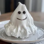 ['A close-up view of a Meringue Ghost with a glossy white exterior and dark accents.', 'Juicy Meringue Ghost showcasing a side profile adorned with dark chocolate and black food coloring.', 'Detailed side view of a Meringue Ghost highlighting its smooth texture and unique color.', 'Close-up image of a Meringue Ghost featuring swirls of black food coloring and a shiny surface.']