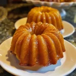 ['Side view of a moist Pumpkin Bundt Cake on a white plate with a smooth glaze.', 'Close-up of Pumpkin Bundt Cake showcasing its rich texture and spiced glaze.', 'A detailed view of a sliced Pumpkin Bundt Cake revealing its fluffy interior and toppings.', 'Side angle of a beautifully decorated Pumpkin Bundt Cake with a light drizzle of icing.']