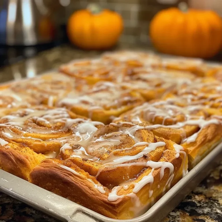 ['Close-up view of pumpkin cinnamon roll focaccia, showcasing its swirled filling and glazed top.', 'Side view of a golden-brown pumpkin cinnamon roll focaccia, highlighting its fluffy texture and sweet glaze.', 'Detailed image of a slice of pumpkin cinnamon roll focaccia with visible cinnamon swirls and icing.', 'Juicy pumpkin cinnamon roll focaccia with a glossy glaze, presented from a side angle.']