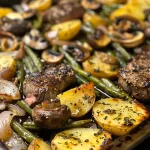 ['Close-up view of a sheet pan filled with juicy steak and colorful roasted vegetables.', 'A side view of a delicious sheet pan steak, surrounded by vibrant broccoli, bell pepper, and potatoes.', 'Juicy sirloin steak with an array of roasted veggies including broccoli and red onion on a sheet pan.', 'A beautifully arranged sheet pan featuring succulent steak and assorted roasted vegetables.']