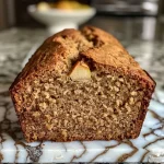 ['Close-up of a slice of spiced pear bread showing a moist texture with pieces of pear.', 'Side view of freshly baked spiced pear bread with a golden-brown crust and visible pear chunks.', 'A slice of spiced pear bread revealing its fluffy interior and spices, garnished with a light glaze.', 'Detailed view of spiced pear bread highlighting its rich brown color and specks of cinnamon.']