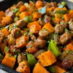 ['Close-up of a colorful Sweet Potato Sausage Skillet with diced vegetables.', 'Side view of a hearty Sweet Potato Sausage Skillet, showcasing vibrant bell peppers and sausage.', 'Juicy Sweet Potato Sausage Skillet filled with sweet potatoes, sausage, and mixed vegetables.', 'A delicious Sweet Potato Sausage Skillet full of fresh ingredients and garnished beautifully.']