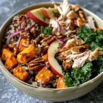 ['A close-up side view of a colorful autumn grain bowl featuring wild rice, quinoa, sweet potato, chicken, and greens.', 'A vibrant cozy grain bowl filled with various ingredients like diced sweet potatoes, kale, and chopped nuts, captured from a side angle.', 'A side view of a delicious grain bowl showcasing layers of quinoa, roasted vegetables, and fresh apple, taken with an iPhone.', 'A detailed image of an autumn-inspired grain bowl with ingredients such as chicken, kale, and walnuts, emphasizing its colorful presentation.']