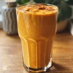 Close-up view of a healthy pumpkin smoothie in a glass, showcasing its creamy texture.