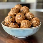Close-up view of No Bake Pumpkin Spice Energy Bites on a wooden surface.